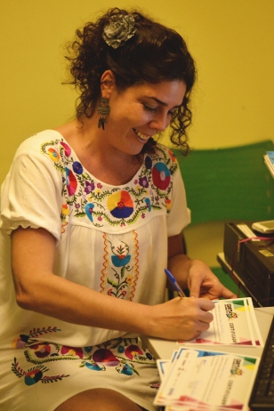 Carol Tanajura, responsável pela Direção de Arte, assina certificado de participantes da oficina
